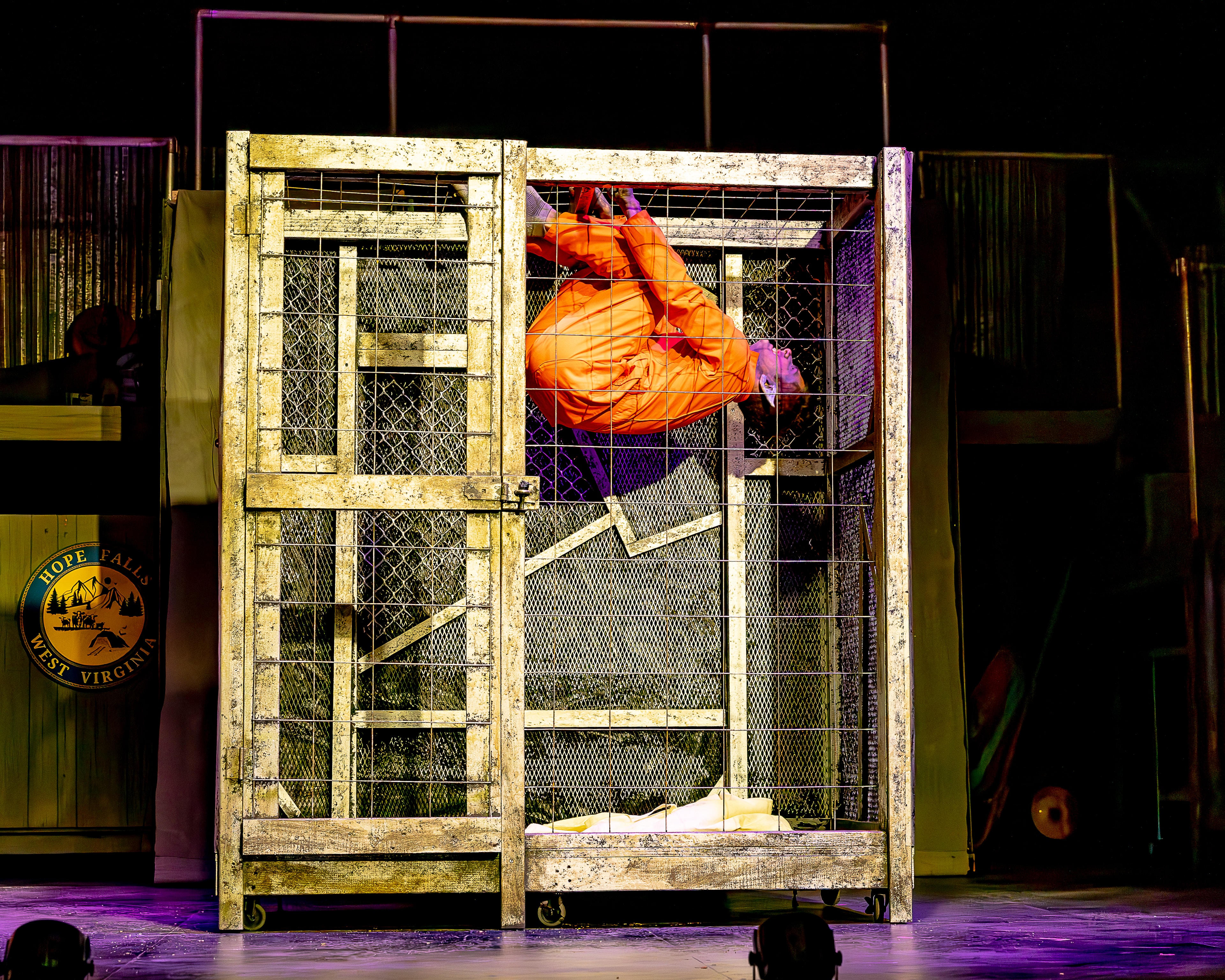 Bat Boy 2024 — neon lit figure in industrial cage display
